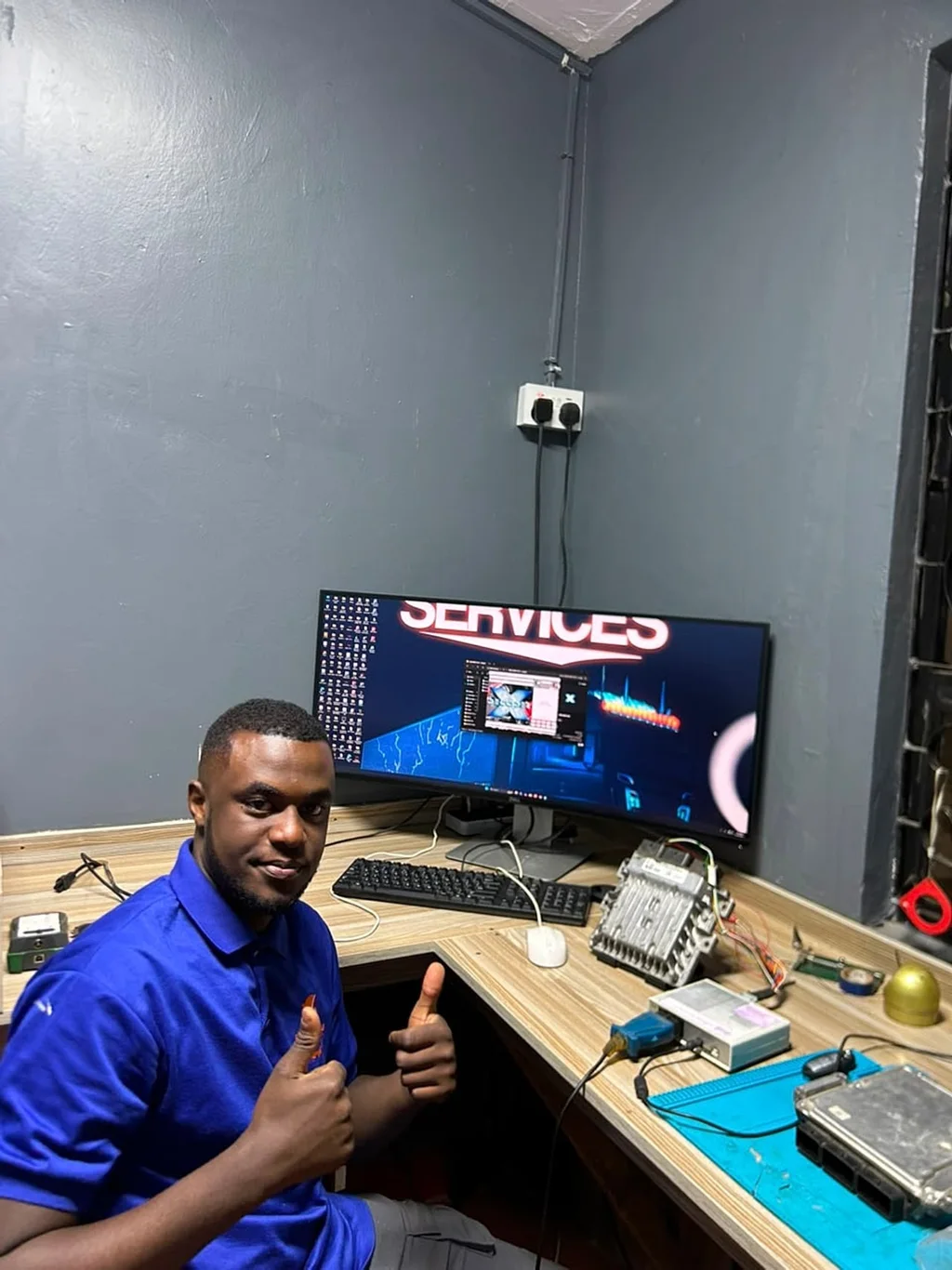 Technician seated at the electronics workstation with control units on the bench